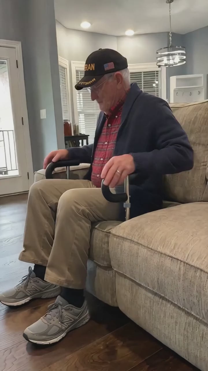Dad pushes on the StandTall handles and stands up from his couch