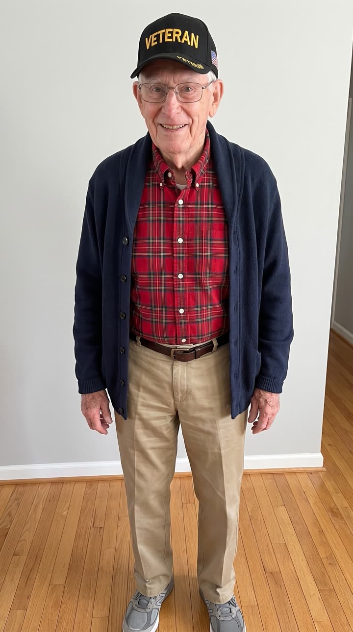 Smiling older man in a veteran cap standing beside his couch